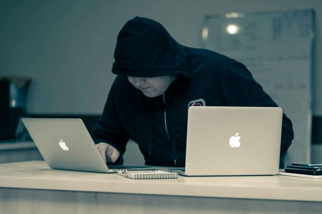 hooded man looking at laptop invading privacy